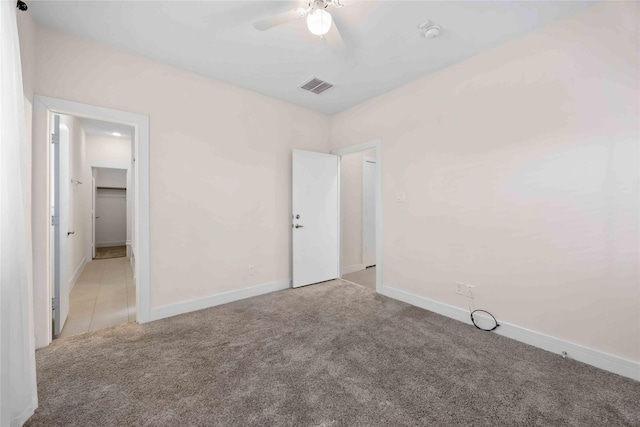 unfurnished bedroom featuring ceiling fan, visible vents, baseboards, and light carpet