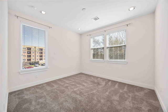 unfurnished room featuring baseboards, carpet flooring, and visible vents