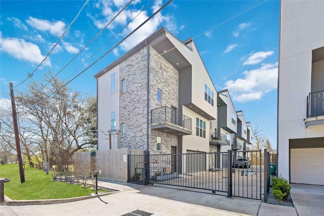 exterior space featuring a gate, fence, stone siding, and stucco siding