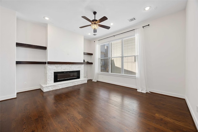 unfurnished living room featuring baseboards, a ceiling fan, visible vents, and a fireplace