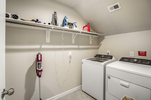 clothes washing area featuring washing machine and dryer, visible vents, baseboards, and laundry area