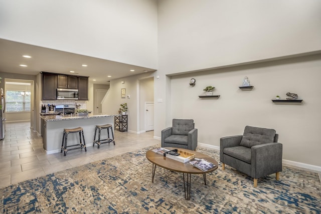 living room featuring light tile patterned floors, baseboards, and recessed lighting