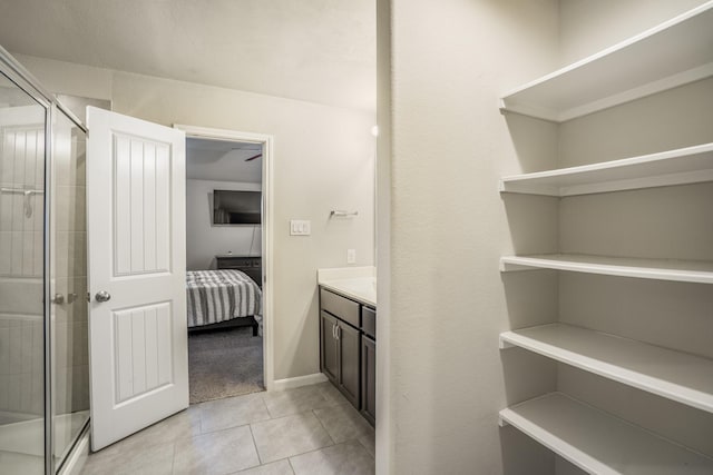 ensuite bathroom with vanity, tile patterned flooring, a stall shower, and connected bathroom