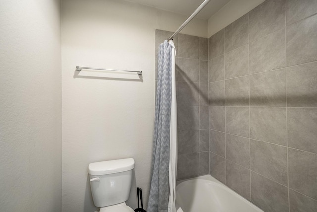 bathroom featuring shower / bathtub combination with curtain and toilet