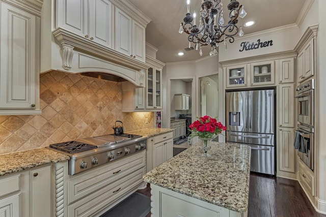 21411 Fairhaven Creek Dr, Cypress, TX 77433 - kitchen featuring stainless steel appliances, light stone countertops, a kitchen island, cream cabinetry, and a chandelier