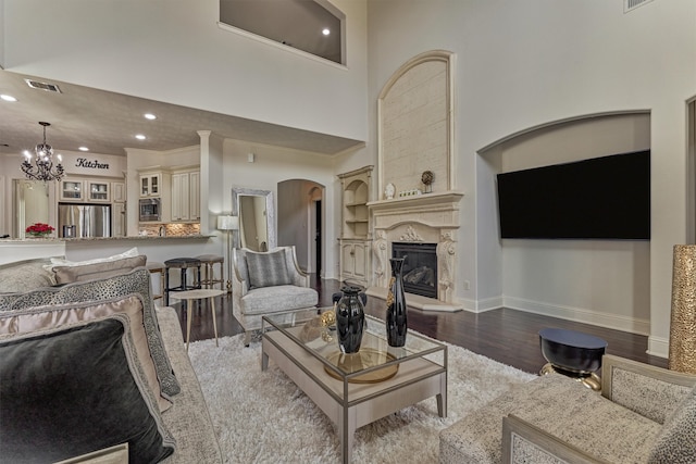 21411 Fairhaven Creek Dr, Cypress, TX 77433 - living area featuring wood finished floors, a glass covered fireplace, a chandelier, recessed lighting, and baseboards