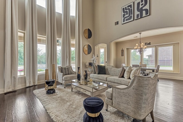 21411 Fairhaven Creek Dr, Cypress, TX 77433 - living area with arched walkways, baseboards, dark wood finished floors, a towering ceiling, and a chandelier