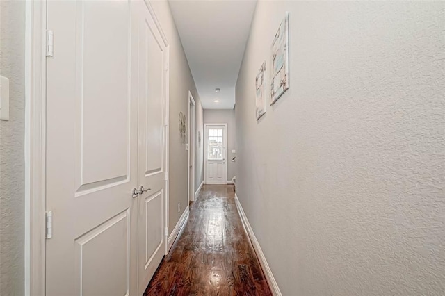 hallway with baseboards and dark wood finished floors