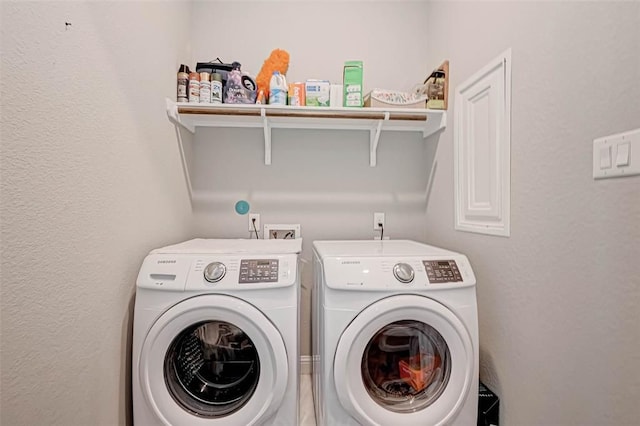 clothes washing area featuring washer and dryer and laundry area
