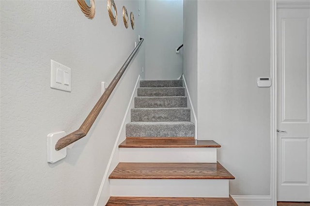 stairway featuring baseboards and wood finished floors