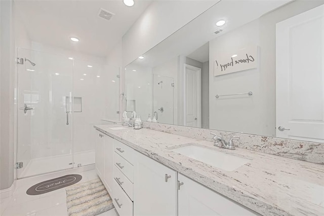 full bath featuring a sink, a stall shower, double vanity, visible vents, and recessed lighting