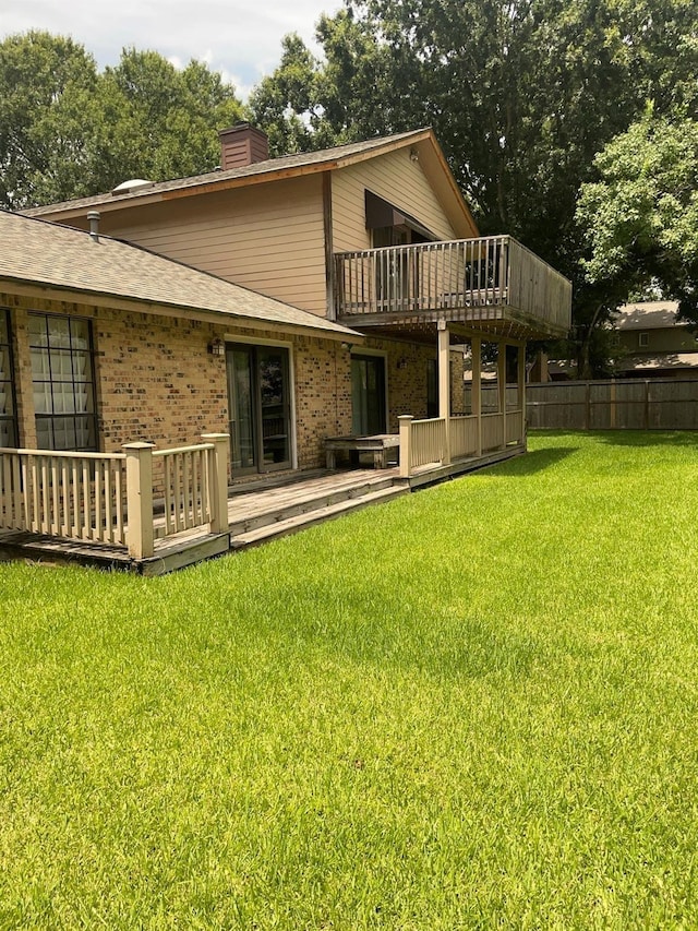 9948 Twin Shores Dr, Willis, TX 77318 - rear view of property featuring brick siding, a lawn, a chimney, and a deck