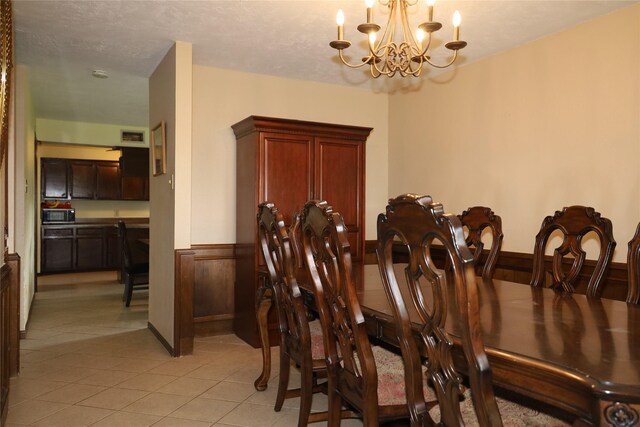 9948 Twin Shores Dr, Willis, TX 77318 - dining room featuring light tile patterned flooring, a chandelier, and a wainscoted wall