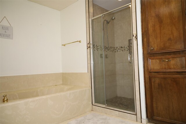9948 Twin Shores Dr, Willis, TX 77318 - bathroom with tile patterned floors, a bath, and a stall shower