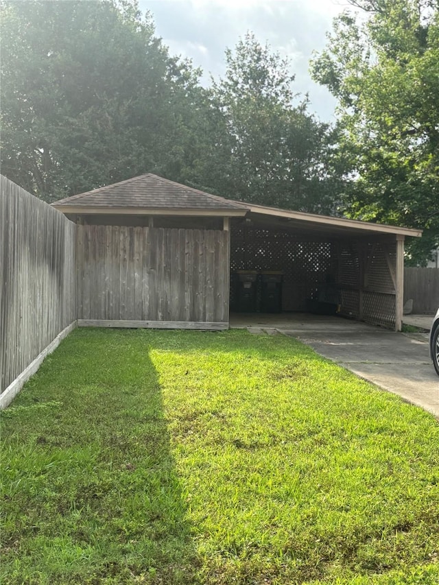 9948 Twin Shores Dr, Willis, TX 77318 - view of outdoor structure with concrete driveway, fence, and an attached carport