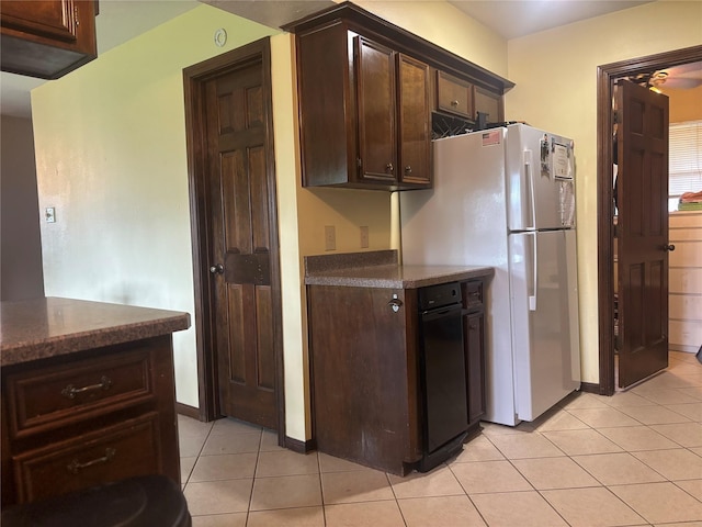 9948 Twin Shores Dr, Willis, TX 77318 - kitchen featuring freestanding refrigerator, dark brown cabinetry, baseboards, and light tile patterned floors