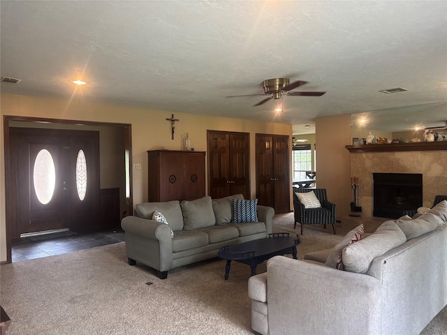 9948 Twin Shores Dr, Willis, TX 77318 - living area featuring visible vents, carpet flooring, a ceiling fan, and a tile fireplace