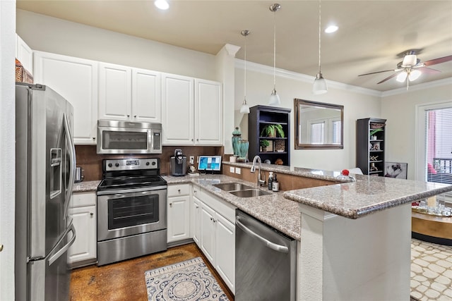 kitchen featuring crown molding, a sink, white cabinets, a peninsula, and appliances with stainless steel finishes