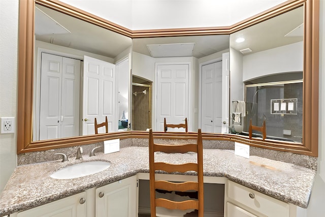 bathroom with a shower stall, vanity, and a closet