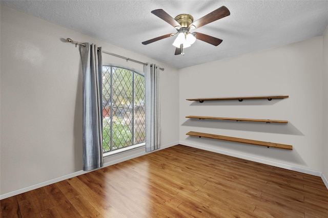 4702 Gulfway Dr, Baytown, TX 77521 - spare room featuring a textured ceiling, a ceiling fan, wood finished floors, and baseboards
