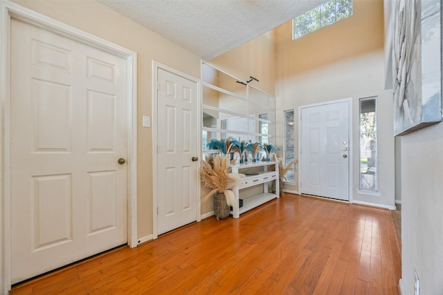 5903 Llano Creek Dr, Katy, TX 77449 - entrance foyer featuring hardwood / wood-style floors, a towering ceiling, a textured ceiling, and baseboards