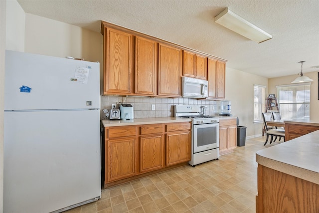 5903 Llano Creek Dr, Katy, TX 77449 - kitchen with white appliances, light countertops, decorative backsplash, a textured ceiling, and brown cabinets