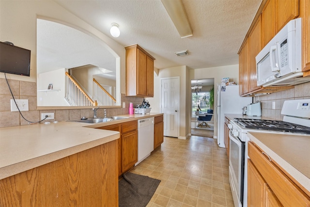 5903 Llano Creek Dr, Katy, TX 77449 - kitchen with white appliances, a sink, backsplash, a textured ceiling, and light countertops