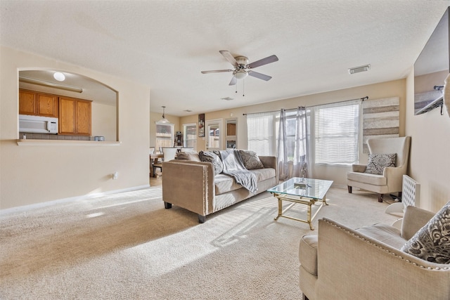 5903 Llano Creek Dr, Katy, TX 77449 - living area with a ceiling fan, light colored carpet, baseboards, and arched walkways