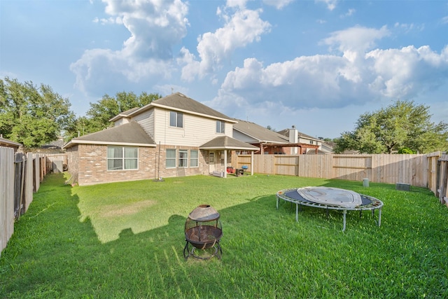 5903 Llano Creek Dr, Katy, TX 77449 - back of property with an outdoor fire pit, a trampoline, brick siding, and a gazebo