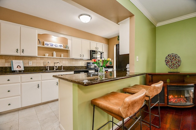 6415 Olympia Dr Unit 143, Houston, TX 77057 - kitchen with crown molding, open shelves, a sink, black appliances, and decorative backsplash