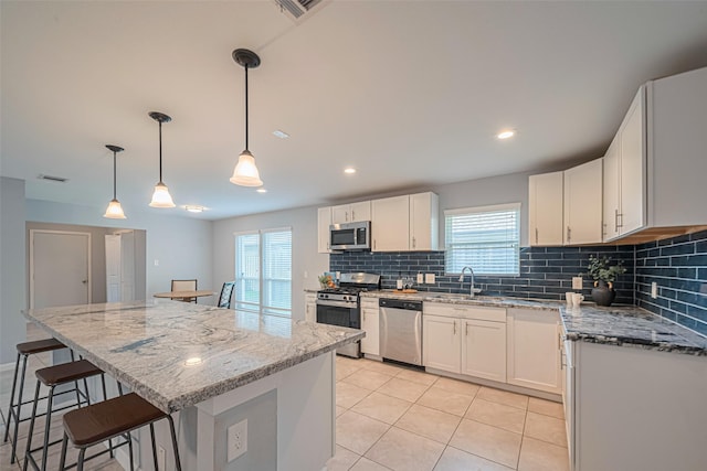 7730 Maple Tree Dr, Houston, TX 77088 - kitchen featuring stainless steel appliances, a sink, tasteful backsplash, a kitchen breakfast bar, and plenty of natural light