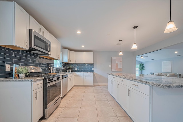 7730 Maple Tree Dr, Houston, TX 77088 - kitchen with appliances with stainless steel finishes, tasteful backsplash, white cabinets, light tile patterned flooring, and light stone countertops