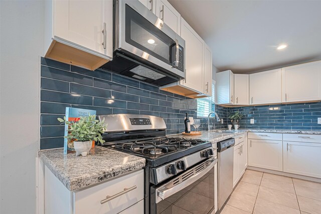 7730 Maple Tree Dr, Houston, TX 77088 - kitchen with appliances with stainless steel finishes, a sink, and white cabinets