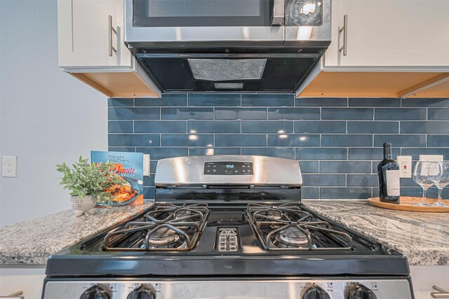 7730 Maple Tree Dr, Houston, TX 77088 - kitchen view of stainless steel appliances, white cabinetry, and backsplash