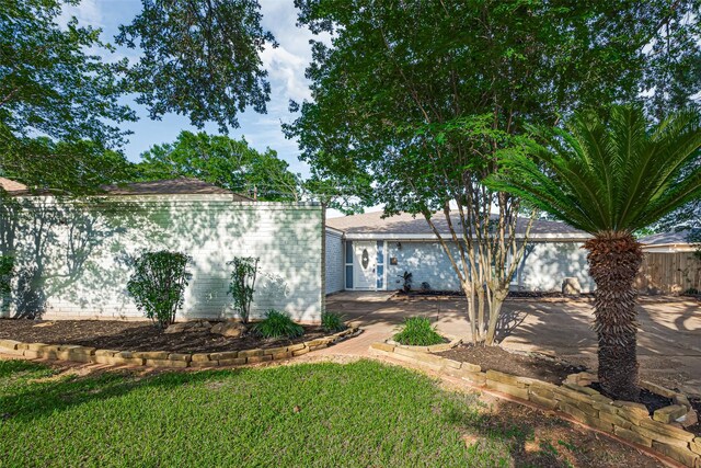 7730 Maple Tree Dr, Houston, TX 77088 - view of front facade featuring fence, a patio, and brick siding