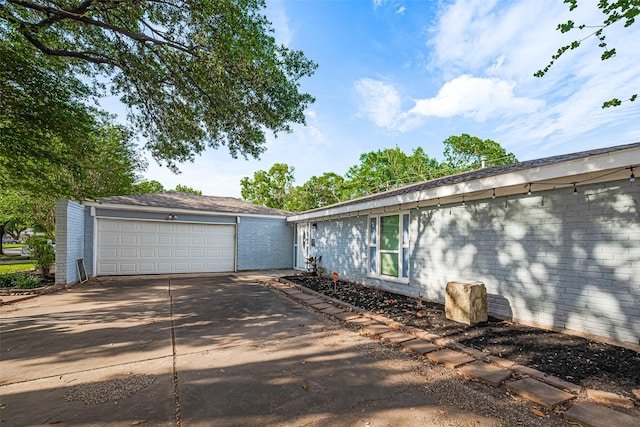 7730 Maple Tree Dr, Houston, TX 77088 - view of property exterior featuring a garage, brick siding, and concrete driveway