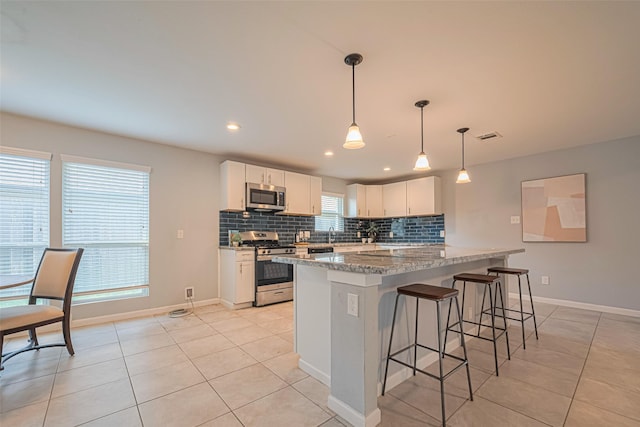 7730 Maple Tree Dr, Houston, TX 77088 - kitchen featuring appliances with stainless steel finishes, light tile patterned flooring, backsplash, a kitchen breakfast bar, and recessed lighting