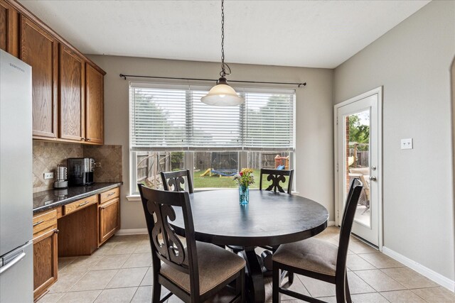 dining area featuring light tile patterned flooring, baseboards, and a wealth of natural light