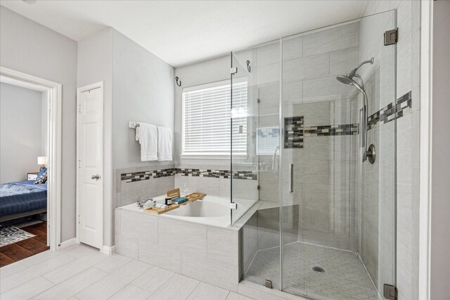 ensuite bathroom with tile patterned floors, baseboards, a shower stall, ensuite bathroom, and a bath