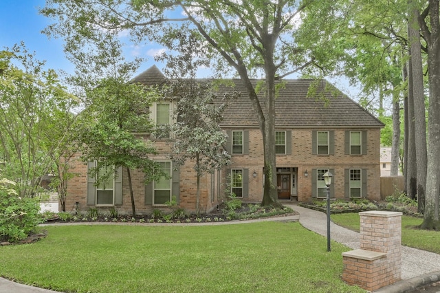 view of front facade with a front yard and brick siding