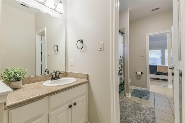 ensuite bathroom with tile patterned floors, curtained shower, vanity, and visible vents