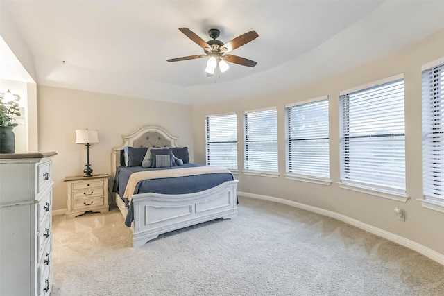 bedroom with light colored carpet, ceiling fan, and baseboards
