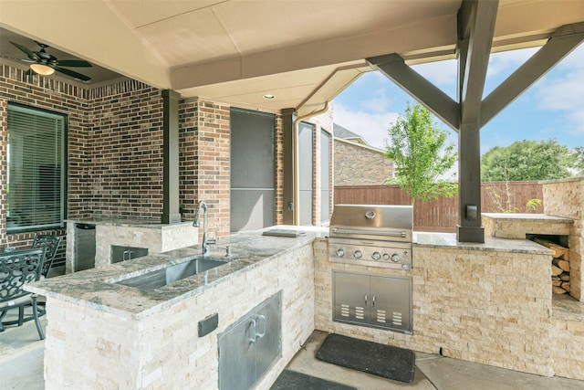 view of patio featuring a grill, an outdoor kitchen, fence, and a sink