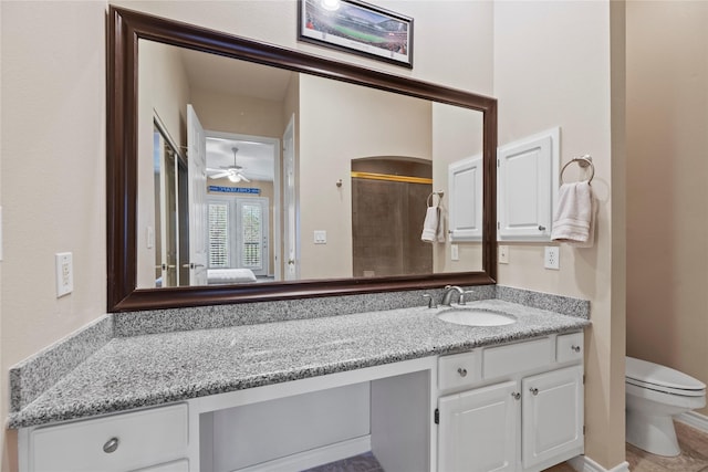 bathroom featuring toilet, a ceiling fan, vanity, and a shower