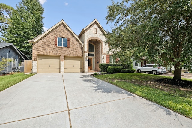traditional-style home featuring brick siding, an attached garage, driveway, and a front yard