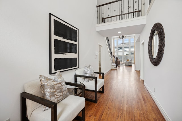 hall with baseboards, wood finished floors, and stairway