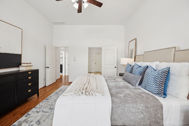 bedroom featuring baseboards, a ceiling fan, wood finished floors, and visible vents