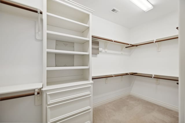 walk in closet featuring visible vents and light carpet