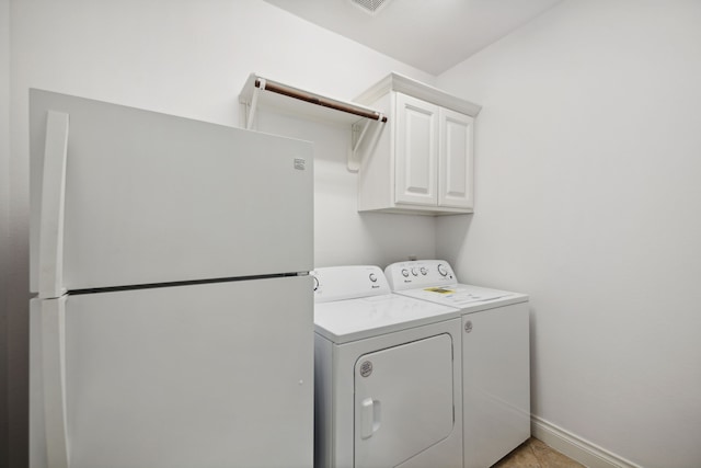 laundry room with separate washer and dryer, baseboards, and cabinet space