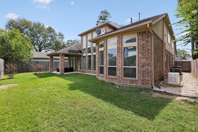 back of property featuring a fenced backyard, a patio, a yard, and brick siding